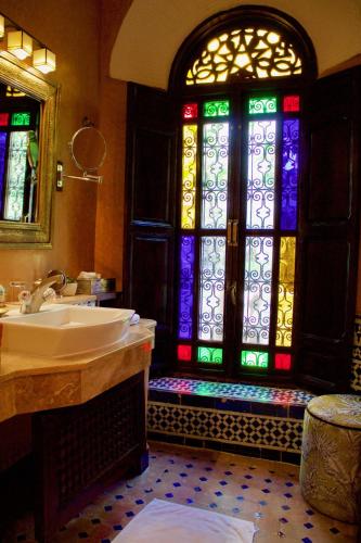 a bathroom with a sink and a stained glass window at Riad Le Calife in Fès