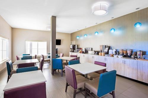 ein Restaurant mit Tischen und Stühlen und eine Küche in der Unterkunft La Quinta by Wyndham Pharr North McAllen in Pharr