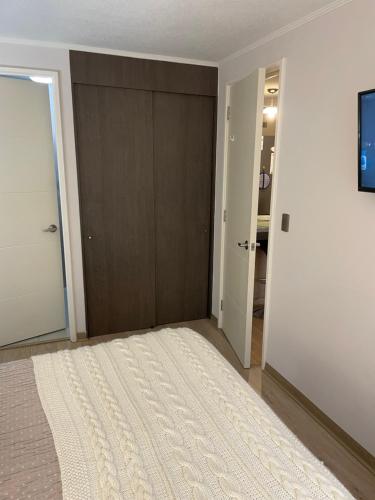 a bedroom with a large bed and a sliding door at Apart Hotel R&P Depto B in Puerto Varas