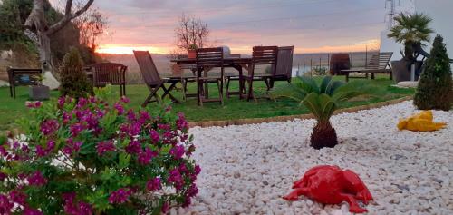 a garden with a table and chairs and flowers at ***** Quinta Do Pôr do Sol ***** in Figueira da Foz