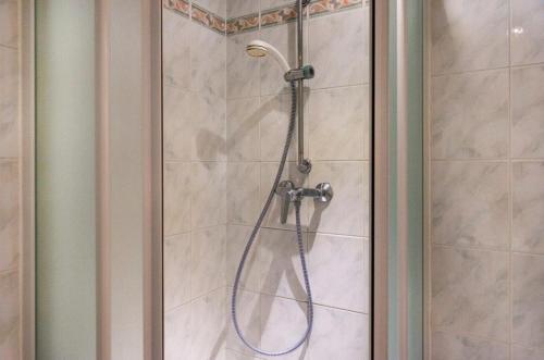 a shower with a blue hose in a bathroom at Familia Hotel in Paris