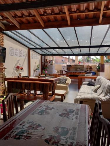 sala de estar con mesas y sillas y cocina en Pousada Cantinho da Tia Sandra- suite 7, en São Francisco do Sul
