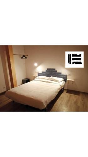 a bedroom with a large bed with white sheets at Casa rural Lastoetxe in Larrauri