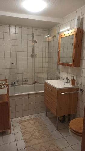 a bathroom with a tub and a sink and a mirror at Fewo - Charmante 2 Zimmer Wohnung mitten in Markdorf in Markdorf