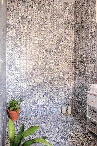 y baño con ducha y pared de azulejos. en MonKeys Apartments Sanlúcar Beach Relax, en Sanlúcar de Barrameda