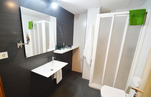 La salle de bains est pourvue d'un lavabo blanc et d'un miroir. dans l'établissement Apartamento Encanto Tarazona Plaza de España, à Tarazona de Aragón
