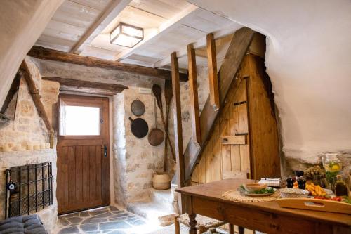 a kitchen with a wooden door and a table at Dandy Villas Mani - Old Tower House - Fireplace - Pool in Nómia