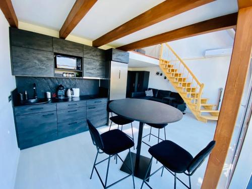 a kitchen with a table and chairs and a staircase at Sea & Sunset View Apartment In Palanga in Palanga