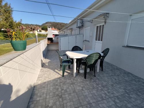 a patio with a table and chairs on a house at Holiday home and weekends, 4 in Esposende