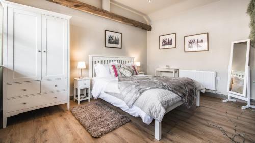 a bedroom with a white bed and two night stands at The Old Tractor Shed in Barmston