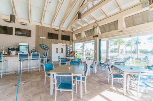 a dining room with tables and chairs and windows at Stunning Views!!-Oceanfront Villa-Heated Pool-Private Balcony-Tiki Bar-Walk to Coligny Plaza in Hilton Head Island