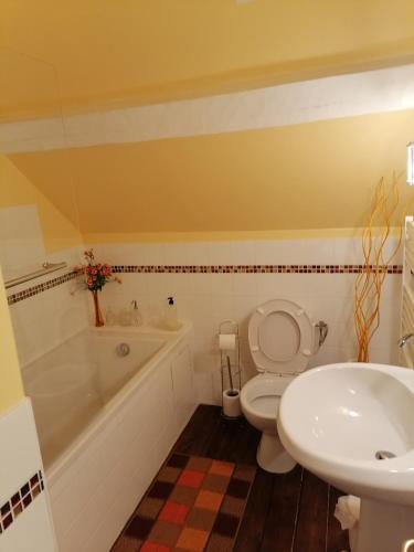 a bathroom with a tub and a toilet and a sink at Manoir du Clap in La Cerlangue