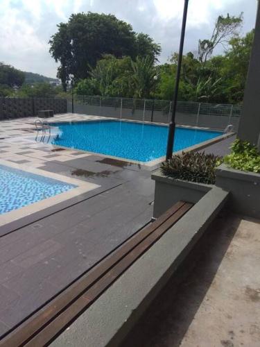 a swimming pool with blue water in a yard at 3Rooms 10pax MC 5 star hotel Sofa&Bed MRT McD Axiata in Seri Kembangan