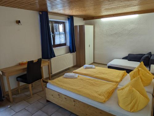 a bedroom with two beds and a desk and a table at Hotel Pension Winzerhaus in Bacharach