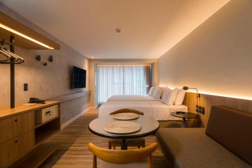 a hotel room with a bed and a table at Hotel Luzeiros Fortaleza in Fortaleza