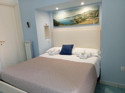 a bedroom with a bed with a painting on the wall at Borgo 800 in San Nicola Arcella