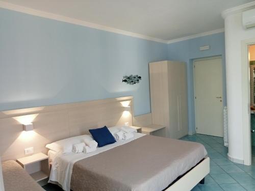 a bedroom with a large bed with blue walls at Borgo 800 in San Nicola Arcella