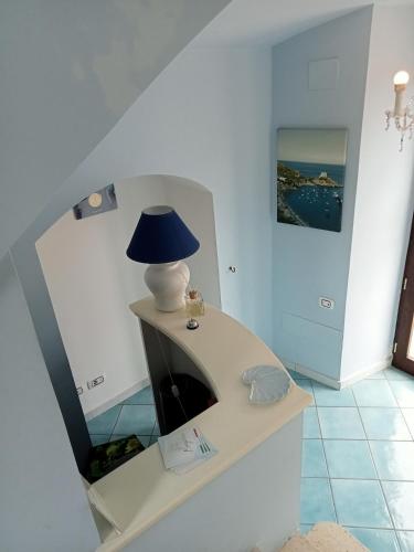 a lamp sitting on a table with a mirror at Borgo 800 in San Nicola Arcella