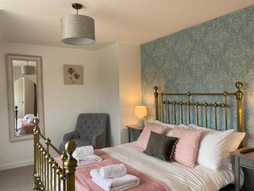 een slaapkamer met een bed, een stoel en een spiegel bij The Countryman in St Ives