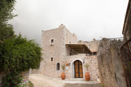 an old stone building with a door on a street at Dandy Villas Mani - Old Tower House - Fireplace - Pool in Nómia