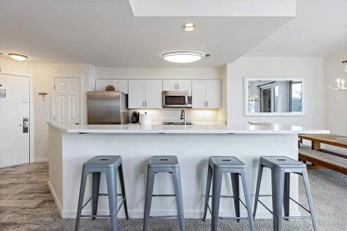 a kitchen with three bar stools and a counter at Diamond Adventure Slope Side with Foosball and Arcade at Wintergreen Resort in Wintergreen