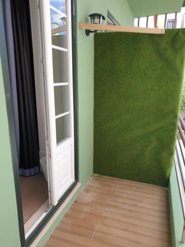 a room with a green wall next to a door at Graça Garden Torres Vedras in Torres Vedras