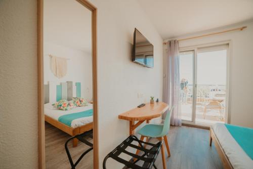 a bedroom with a mirror and a bed and a table at Sunrise Beach Hotel in Gruissan