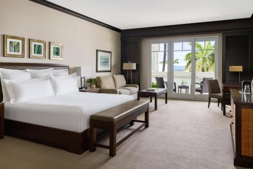 デルレイビーチにあるThe Seagate Hotel & Spaのベッドルーム(大型ベッド1台付)、リビングルームが備わります。