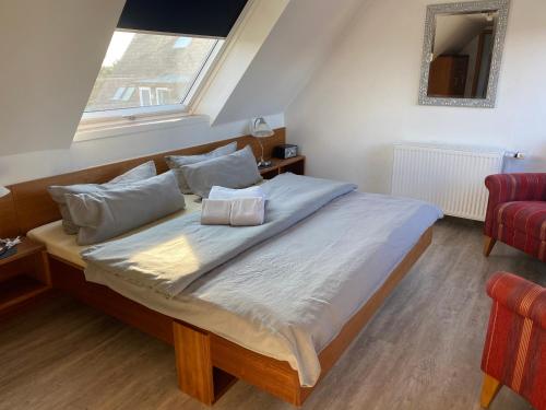 a bedroom with a large bed with a window at Haus Kap Horn in Juist