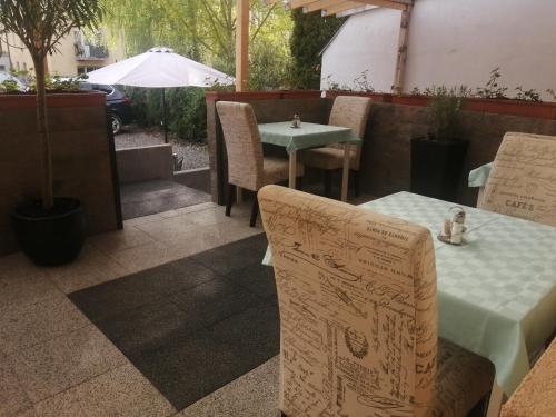 a table and chairs sitting on a patio with a table and a table and chairs at Filsdeger Ház - Central Rooms & Apartmans in Eger