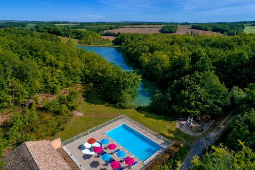 - une vue aérienne sur une piscine avec des parasols dans l'établissement LE HAMEAU DES ETOILES, à Fleurance