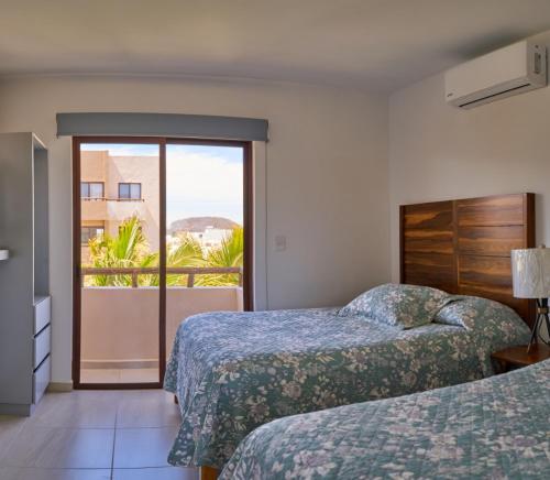 a hotel room with two beds and a balcony at AMBAR BY HAUSING - Pet Friendly in Mazatlán