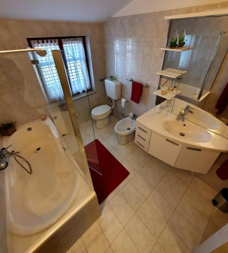 a bathroom with a tub and a toilet and a sink at Lux D'Or Apartment in Pula