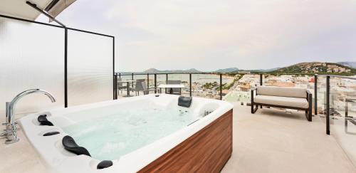 a bathtub in a bathroom with a view of the ocean at Hoposa Daina- Adults Only in Port de Pollensa