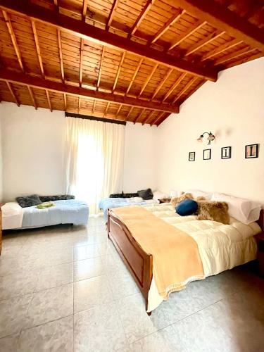 a bedroom with two beds and a large window at Casa Veronica - accogliente casa su due piani nel cuore del borgo in Làconi