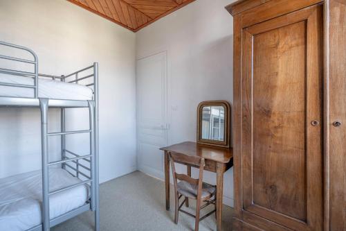 a bedroom with a bunk bed and a desk with a mirror at Demeure familiale de Préfailles pour 12 personnes in Préfailles