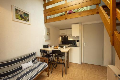 Cette chambre comprend un lit, une table et une cuisine. dans l'établissement Appartement à 900m de la plage aux Sables d'Olonne, à Les Sables-dʼOlonne