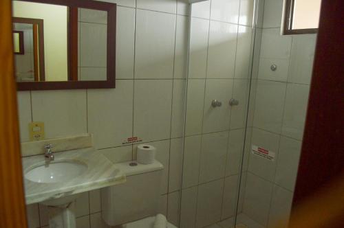a bathroom with a toilet and a sink and a mirror at Hotel Costa Dalpiaz in Torres