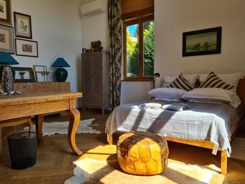 a bedroom with a bed and a table and a window at Heritage Apartment Park Royal Residence in Opatija