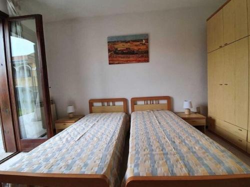 2 aparte bedden in een kamer met een raam bij Pleasant apartment in Feriolo di Baveno on the lake in Fondotoce