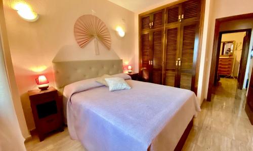 a bedroom with a white bed with a fan above it at Beautiful apartment near LaMata Beach with PANORAMA SEA view!!! in Torrevieja