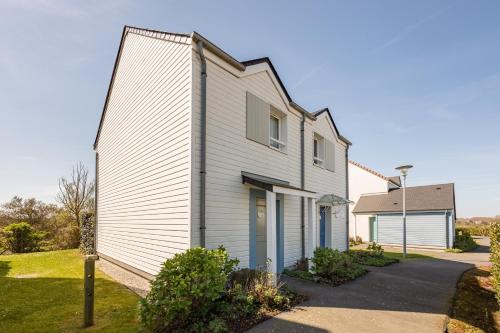 a white house with blue doors at Courlis Cendré in Courseulles-sur-Mer