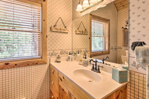 a bathroom with a sink and a mirror at 2-Acre Cabin in Pinetop-Lakeside with Fenced Yard in Pinetop-Lakeside
