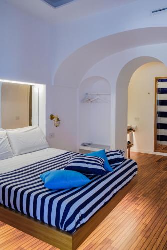 a bedroom with a bed with blue pillows on it at Lampara Mare in Vico Equense