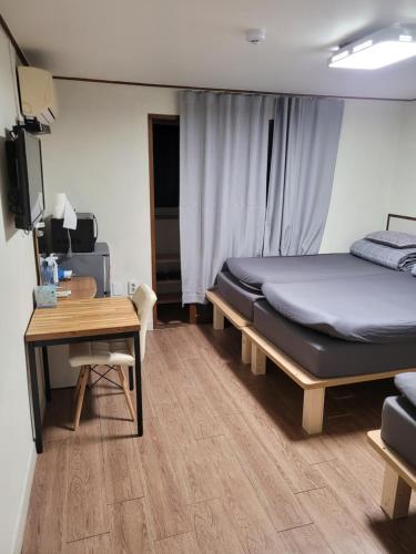 a bedroom with a bed and a table and a desk at Able Guesthouse Hongdae in Seoul