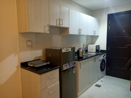 a kitchen with a refrigerator and a washer at AL ALKEEM HEIGHTS in Ras al Khaimah