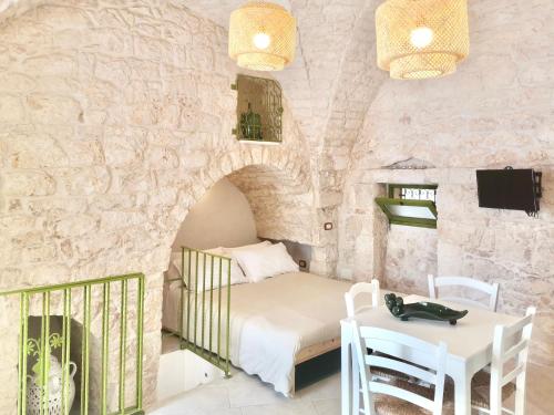 um quarto com uma cama, uma mesa e uma lareira em Il Piccolo Frantoio em Ostuni