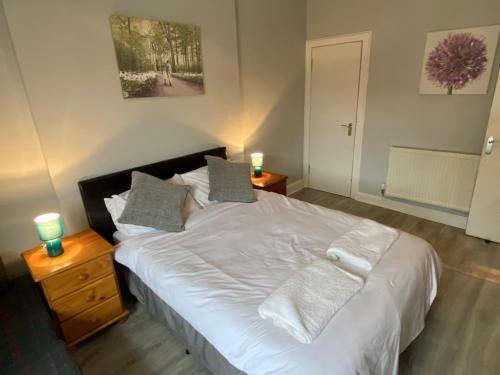 a bedroom with a large white bed with two candles at Grassmarket apartment in Edinburgh