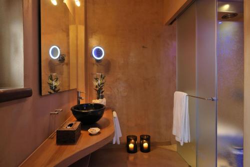 a bathroom with a bowl sink and a shower at Valeni Boutique Hotel & Spa in Portariá