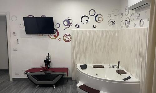 a bathroom with a tub and a tv on the wall at Il Paradiso di Marilyn in Milazzo